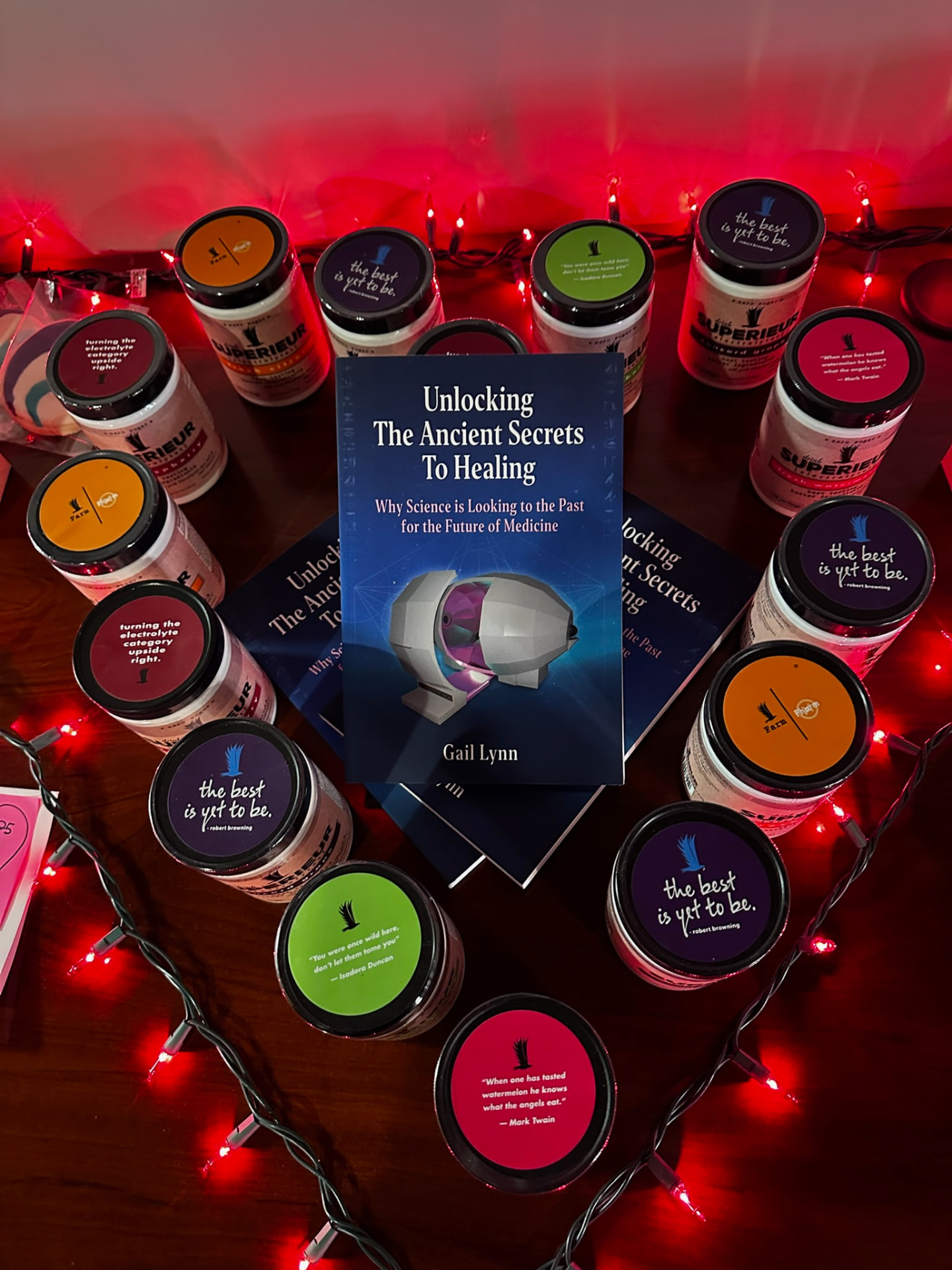 A book display of 'Unlocking The Ancient Secrets To Healing' by Gail Lynn surrounded by candles